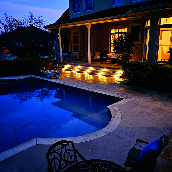Custom backyard patio and pool area with evening lighting – J Field Construction Texas