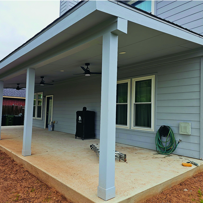 Newly constructed covered back porch with ceiling fans and concrete patio – J Field Construction Texas